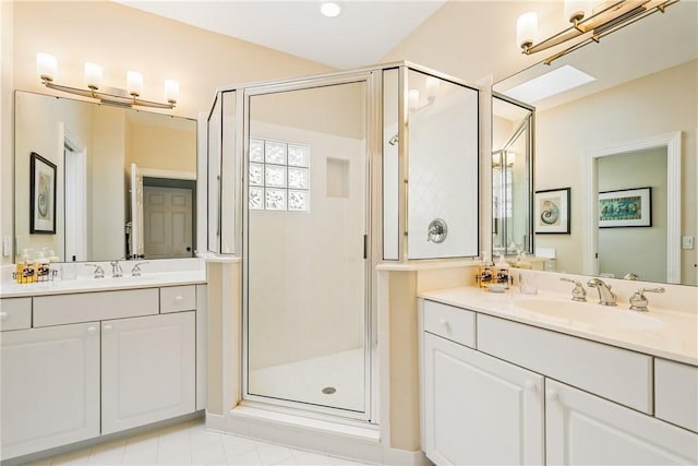 bathroom with vanity, a skylight, tile patterned floors, and walk in shower