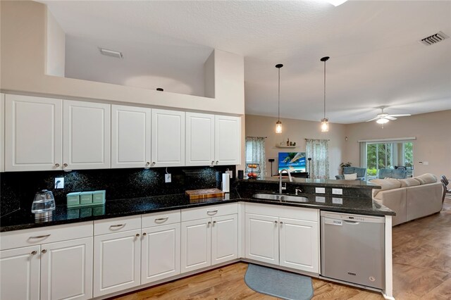 kitchen featuring sink, white cabinetry, dishwasher, kitchen peninsula, and dark stone counters