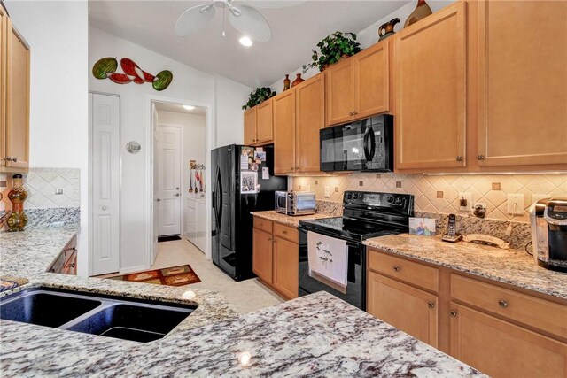 kitchen with light stone countertops, tasteful backsplash, vaulted ceiling, ceiling fan, and black appliances