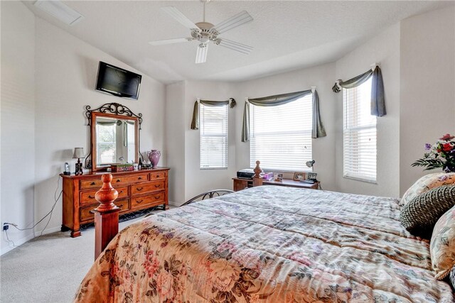 bedroom with multiple windows, ceiling fan, light carpet, and a textured ceiling