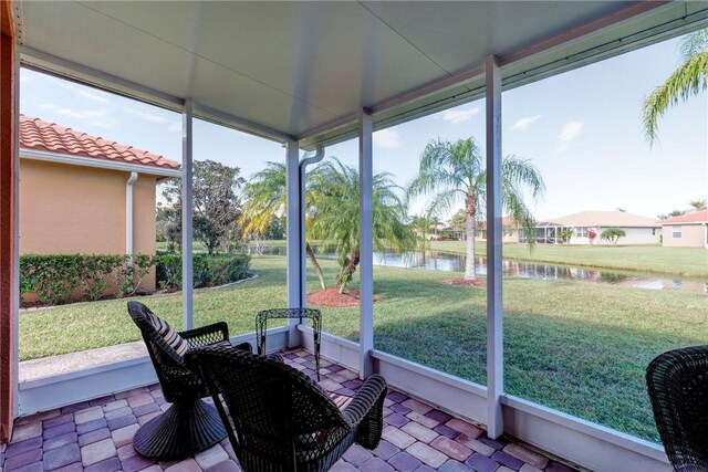 sunroom / solarium featuring a water view