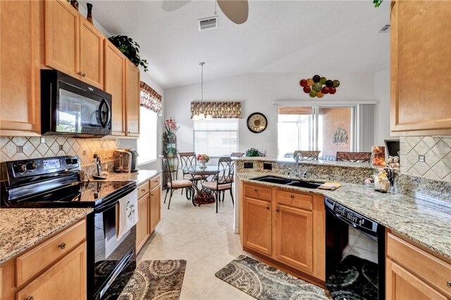 kitchen with plenty of natural light, sink, black appliances, and vaulted ceiling