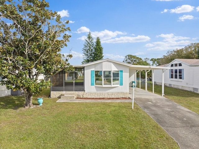 view of front of property featuring a front yard, a sunroom, and a carport