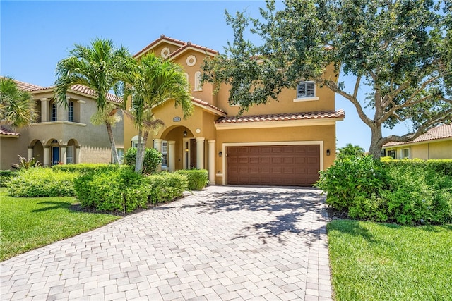 mediterranean / spanish-style home with a front lawn and a garage