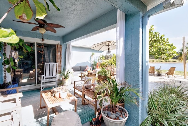 view of patio / terrace with a water view and ceiling fan