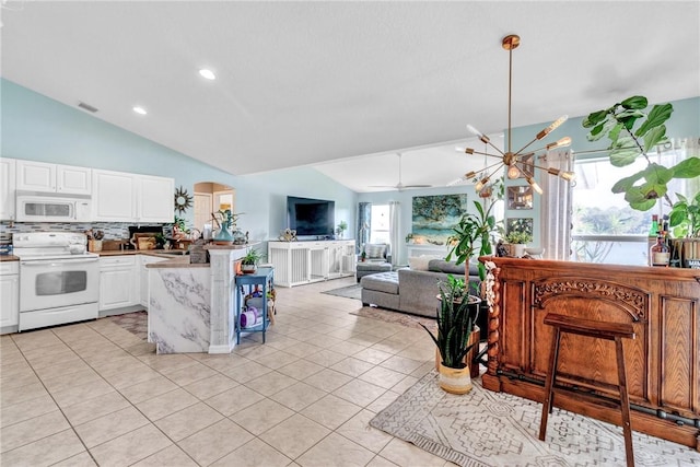 kitchen with white cabinetry, a wealth of natural light, vaulted ceiling, and white appliances