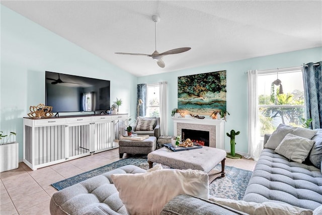 living room featuring ceiling fan, light tile patterned floors, and vaulted ceiling