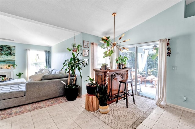 dining area with a healthy amount of sunlight, light tile patterned flooring, lofted ceiling, and a fireplace