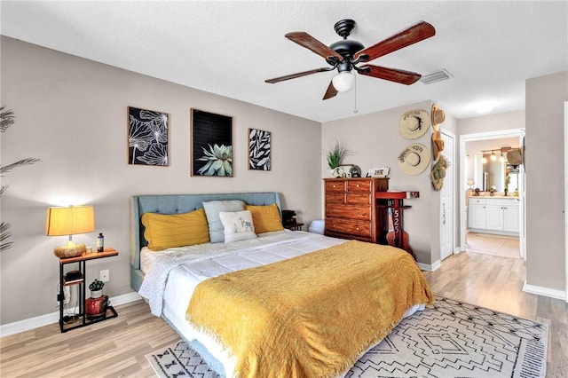 bedroom featuring ceiling fan, light wood-type flooring, and connected bathroom