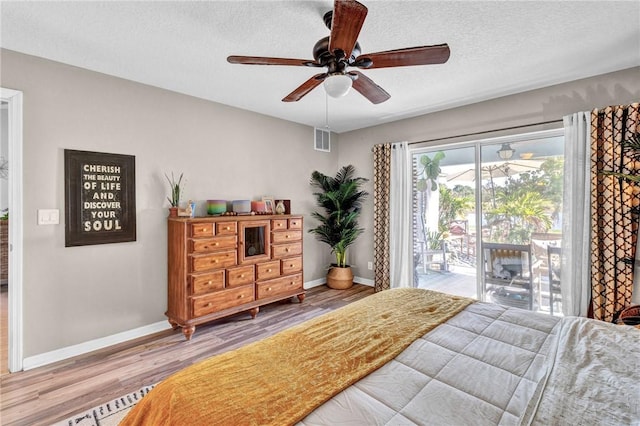 bedroom with a textured ceiling, access to outside, ceiling fan, and hardwood / wood-style flooring