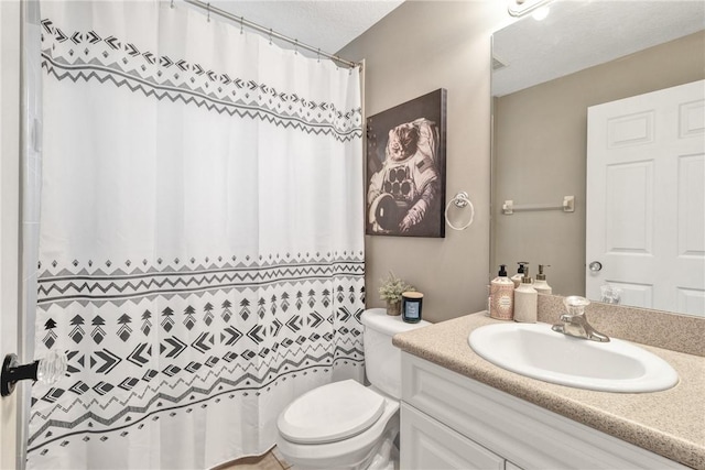 bathroom with vanity, a textured ceiling, and toilet