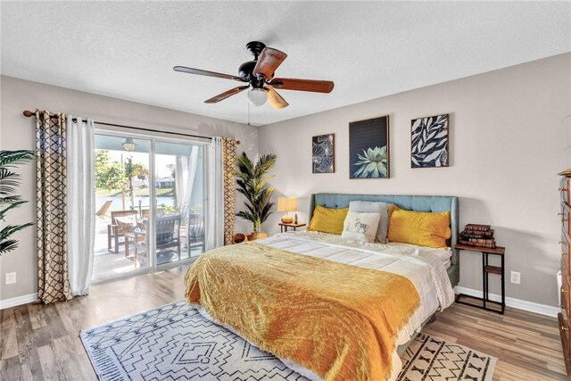 bedroom featuring ceiling fan, a textured ceiling, access to outside, and light hardwood / wood-style flooring