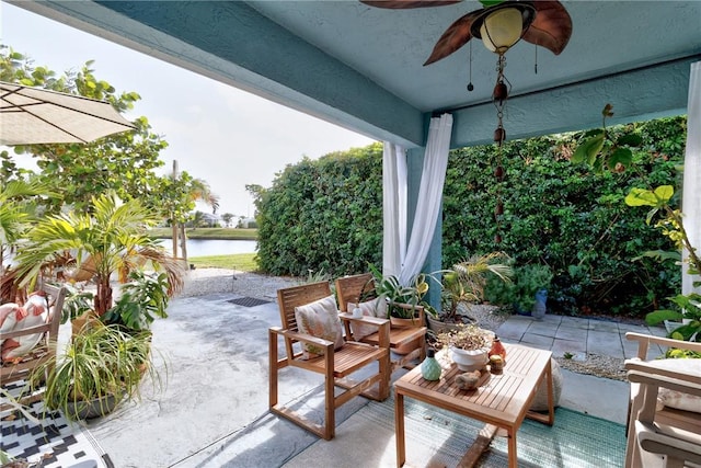 view of patio / terrace featuring a water view and ceiling fan