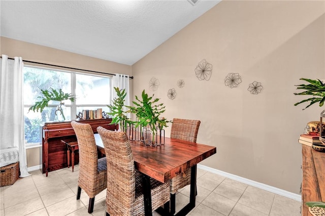 dining area featuring light tile patterned floors, a textured ceiling, and vaulted ceiling