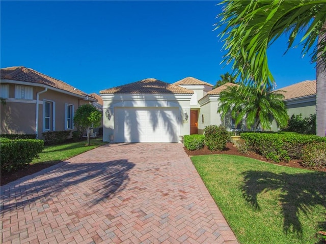 mediterranean / spanish house with a garage and a front lawn