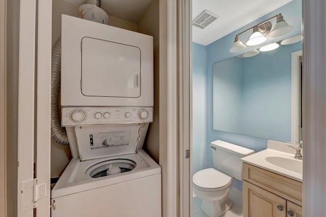 5060 Harmony Cir Unit 307, Vero Beach, FL 32967 - half bathroom featuring stacked washer / drying machine, vanity, and toilet