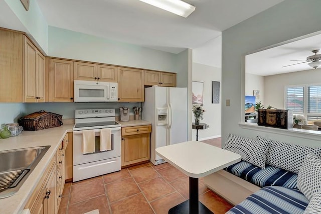 5060 Harmony Cir Unit 307, Vero Beach, FL 32967 - kitchen featuring white appliances, a sink, light countertops, light brown cabinetry, and light tile patterned flooring