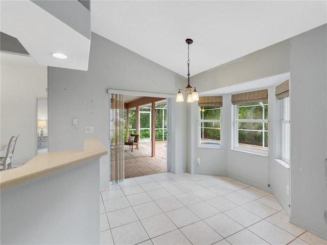 unfurnished dining area with light tile patterned flooring, lofted ceiling, and a chandelier