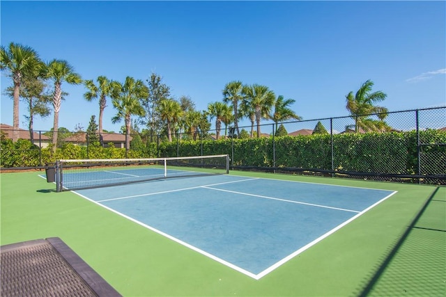 view of tennis court featuring community basketball court and fence