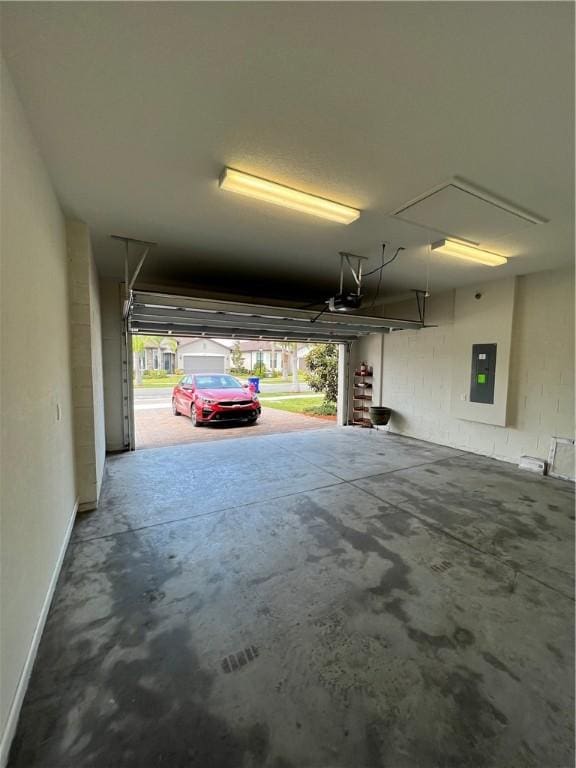 garage featuring electric panel, baseboards, and a garage door opener