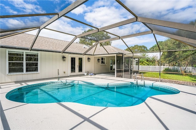 view of pool with french doors, a lanai, and a patio area