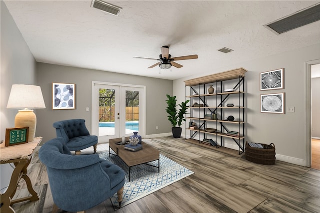 sitting room with french doors, baseboards, ceiling fan, and wood finished floors