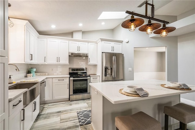 kitchen with stainless steel appliances, lofted ceiling, a sink, under cabinet range hood, and a skylight