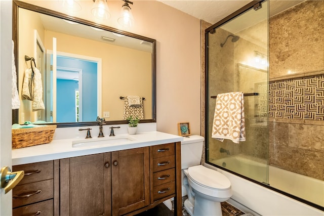 full bathroom with vanity, enclosed tub / shower combo, and toilet