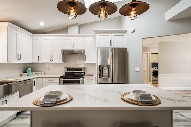 kitchen featuring white cabinetry, washer / clothes dryer, a center island, and appliances with stainless steel finishes