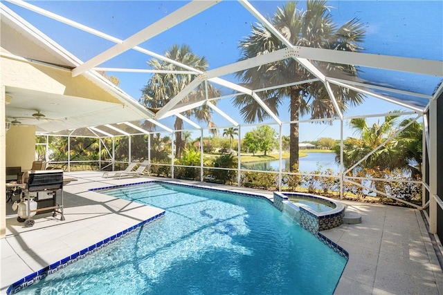 view of pool with glass enclosure, a pool with connected hot tub, ceiling fan, a water view, and a patio area