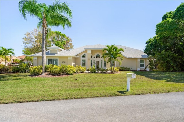 view of front of home with a front yard and stucco siding