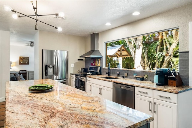 kitchen featuring white cabinetry, sink, wall chimney range hood, and stainless steel appliances