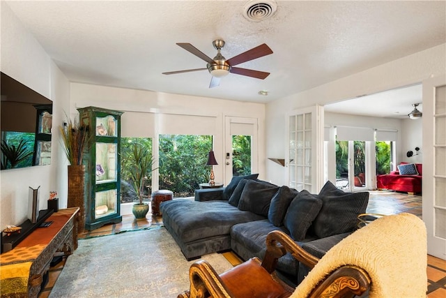 living room featuring ceiling fan and french doors