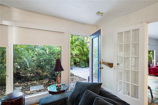 doorway to outside with a textured ceiling