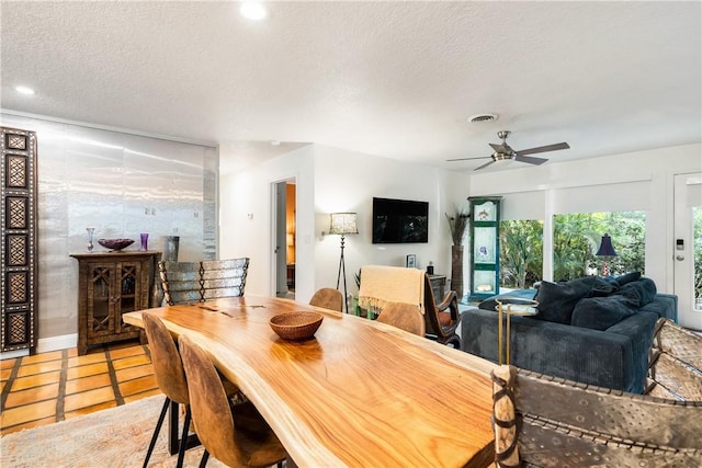 tiled dining area featuring ceiling fan and a textured ceiling