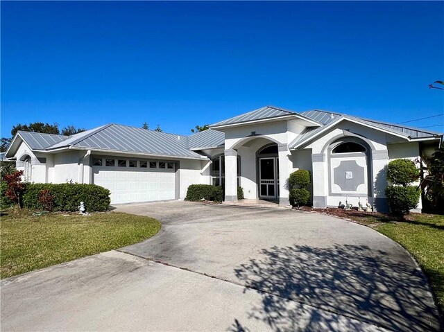 view of front of property featuring a garage and a front lawn