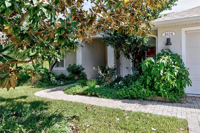 view of side of property with a garage and a lawn