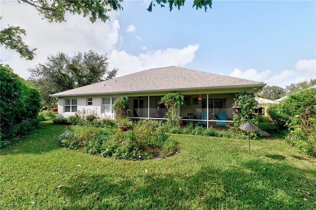 rear view of house with a lawn and a sunroom