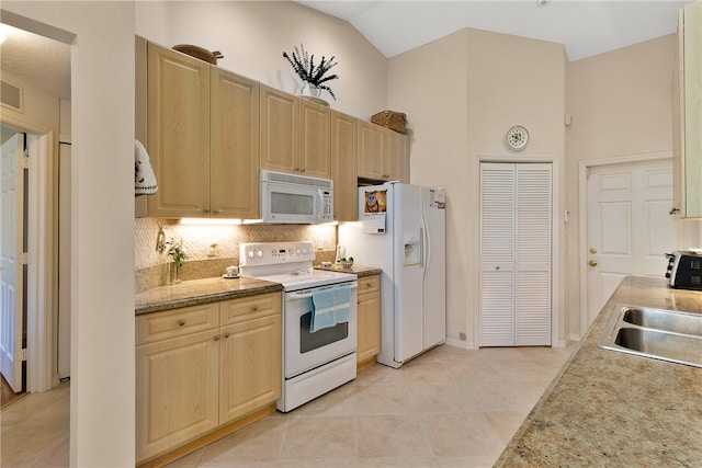 kitchen featuring white appliances, light brown cabinetry, light tile patterned floors, and sink