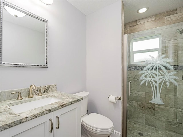 bathroom featuring vanity, toilet, and a shower with door