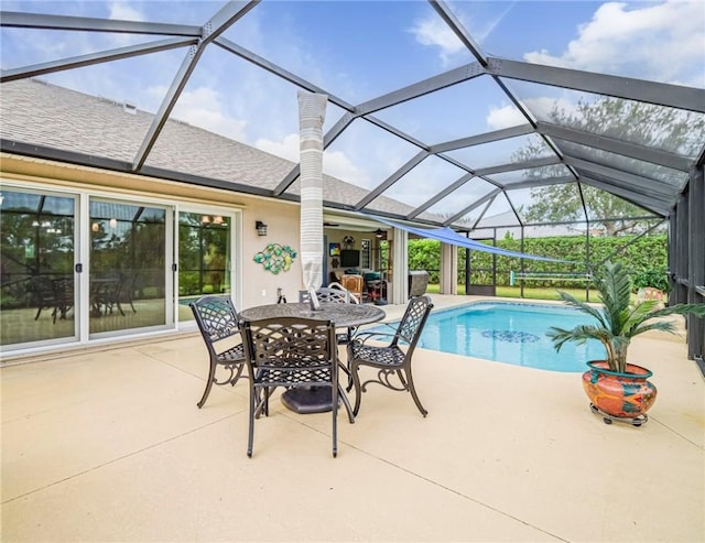 view of pool with glass enclosure and a patio area