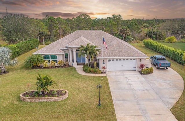 view of front facade with a yard and a garage