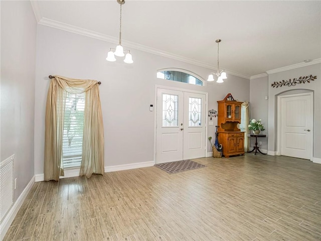 foyer featuring hardwood / wood-style floors, ornamental molding, and an inviting chandelier