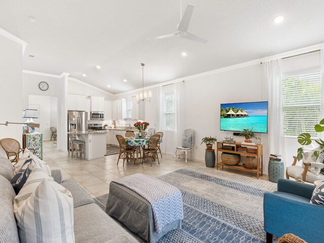 living room featuring vaulted ceiling, light tile patterned floors, ornamental molding, and ceiling fan with notable chandelier