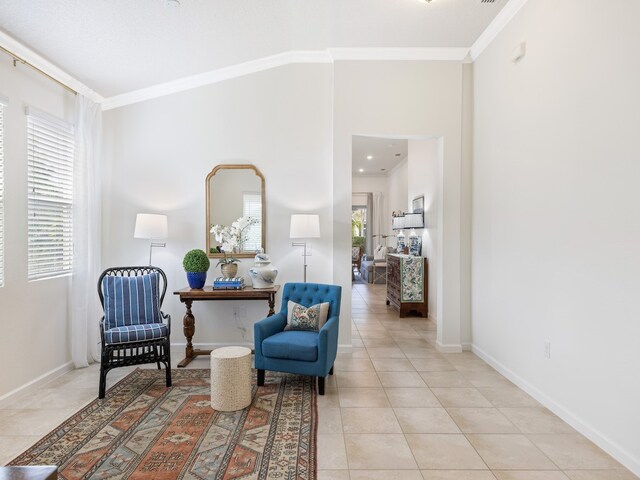 sitting room with a healthy amount of sunlight, light tile patterned floors, and ornamental molding