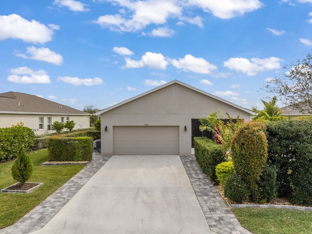 single story home featuring central air condition unit, a garage, and a front yard