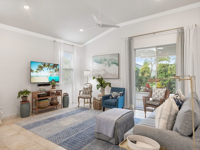 living room with a wealth of natural light, ceiling fan, light tile patterned floors, and vaulted ceiling