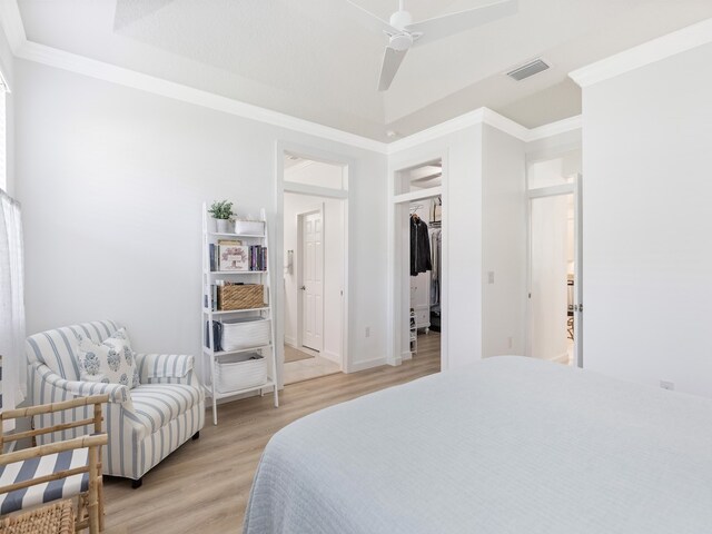 bedroom with ornamental molding, a closet, ceiling fan, and light hardwood / wood-style flooring