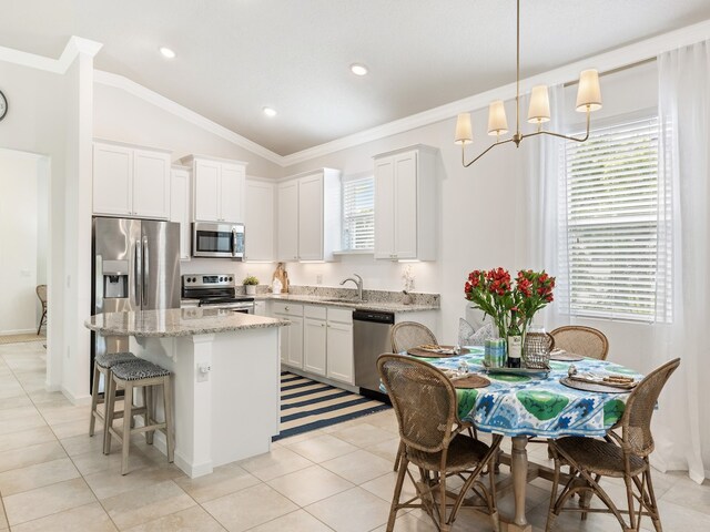 kitchen with vaulted ceiling, white cabinetry, sink, and appliances with stainless steel finishes