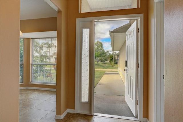 entryway with baseboards and light tile patterned floors